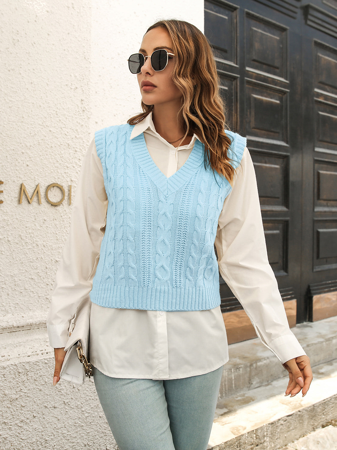 Pastel blue cable knit crop vest sweater with V-neck and ribbed trim.