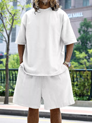 Men's white relaxed fit two-piece set with drawstring shorts and short sleeve t-shirt.