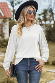 White waffle knit eyelet raglan sleeve top with crew neck and long sleeves.