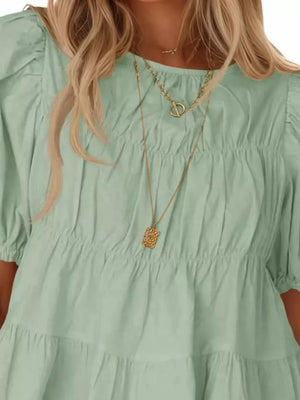 Light green maternity blouse with puff sleeves and tiered ruffled hem.