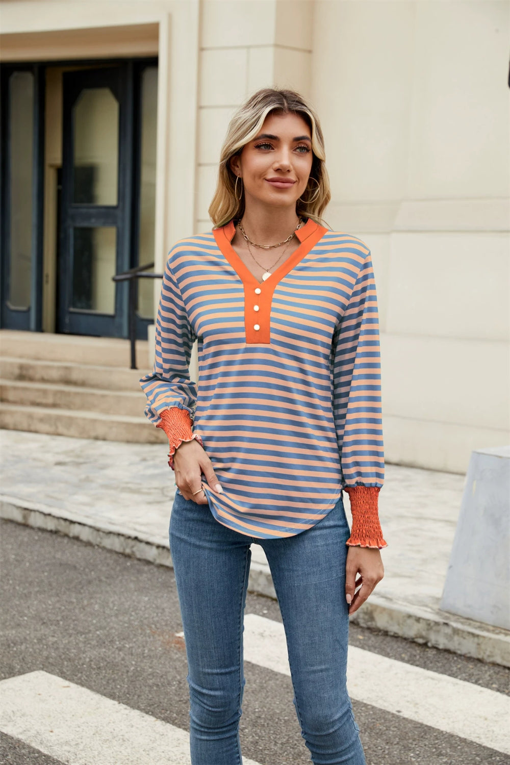 Striped long sleeve blouse in dusty blue and orange with button detail and smocked cuffs.