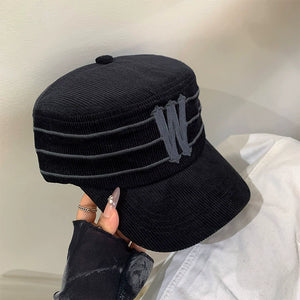Black corduroy baseball cap with horizontal stripes and a gray 'W' applique.