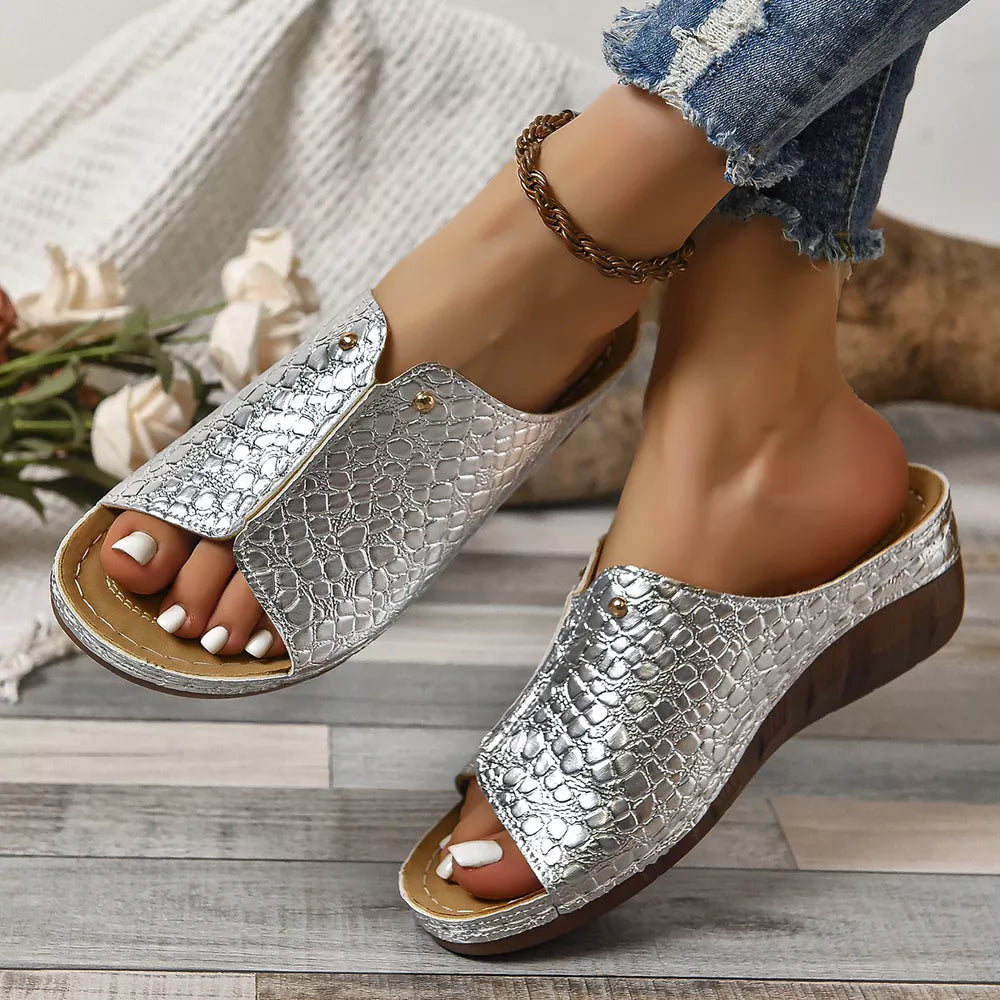 Silver glossy crocodile-embossed wedge sandals with open toe and slip-on style.