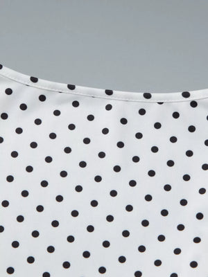 White t-shirt with black polka dots and a ruched detail at the neckline.