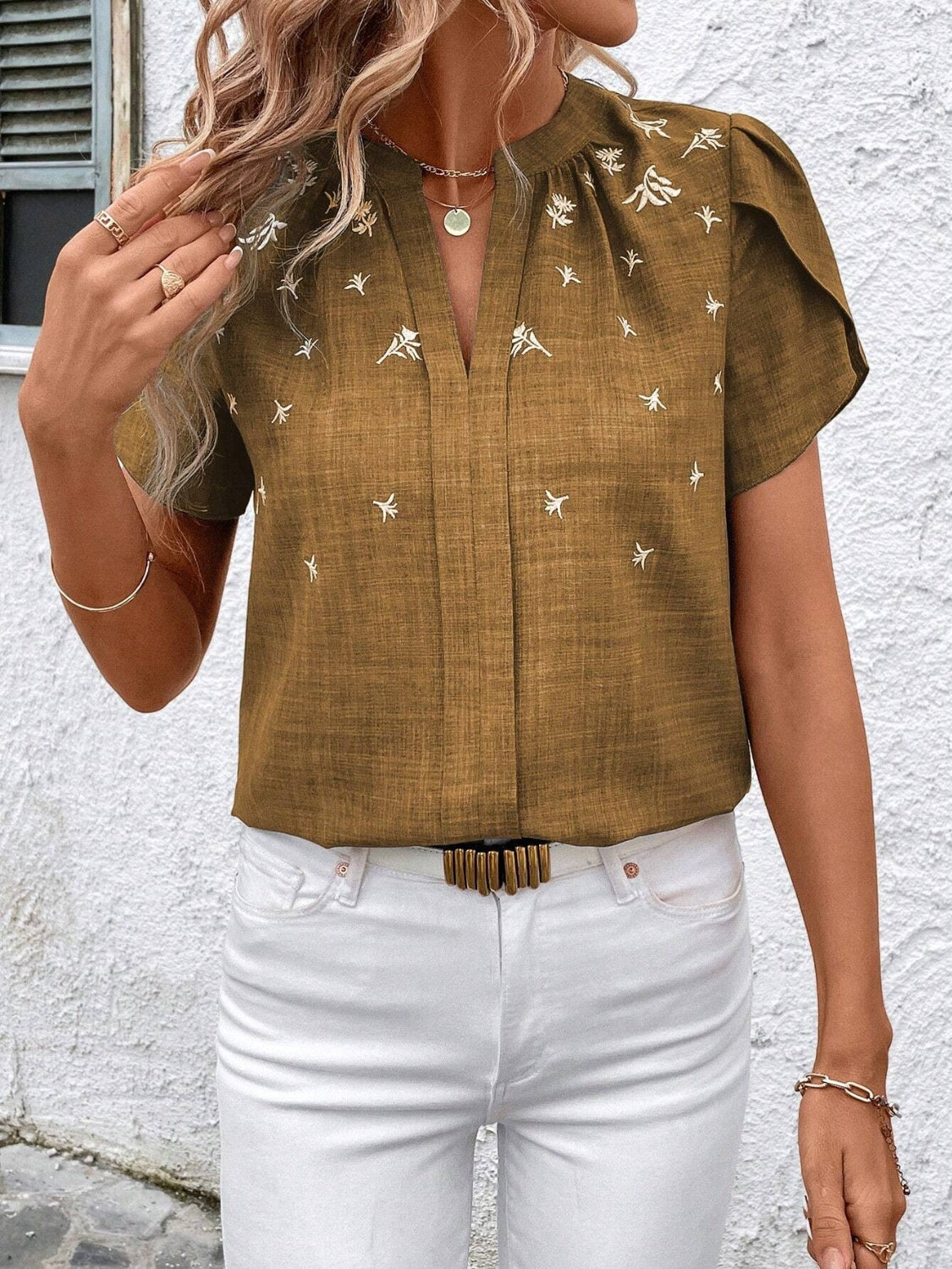 Embroidered floral keyhole blouse in rust with short flutter sleeves and a v-neckline.