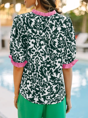 Damask print maternity blouse with ruffled neckline and sleeves in green and pink.