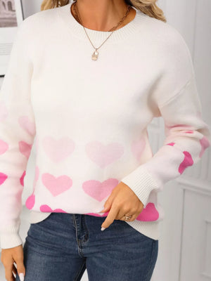 White crew neck sweater with pink heart print, acrylic knit, long sleeves.