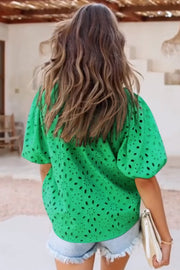 Green eyelet puff-sleeve blouse with a floral cut-out pattern.