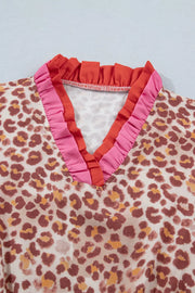 Leopard print V-neck dress with pink and coral ruffled trim detail.