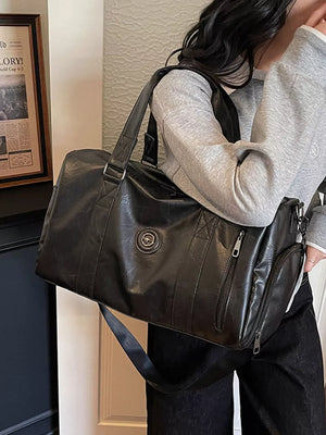 Black pu leather duffel bag with zippered pockets and adjustable strap.