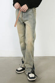 Light wash distressed denim jeans with split hems and zippers.