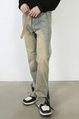 Light wash distressed denim jeans with split hems and zippers.