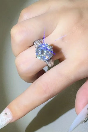 Silver moissanite ring with a large round-cut center stone and pavé band.