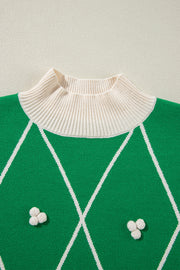 Dark green argyle knit sweater with mock neck and white pom embellishments.