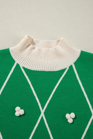 Dark green argyle knit sweater with mock neck and white pom embellishments.