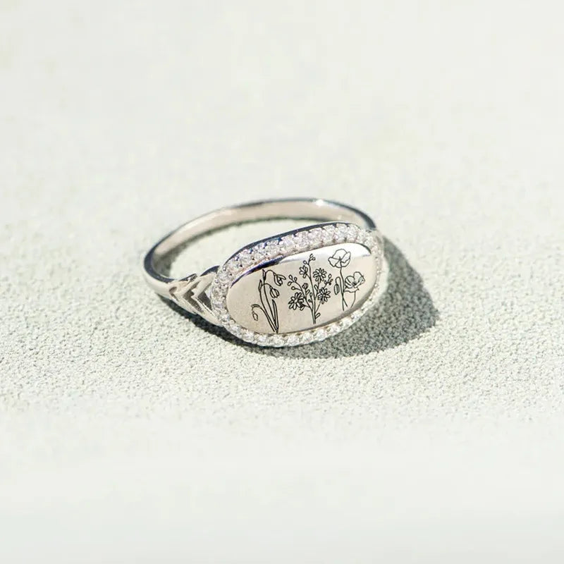 Silver signet ring with engraved floral design and cubic zirconia band