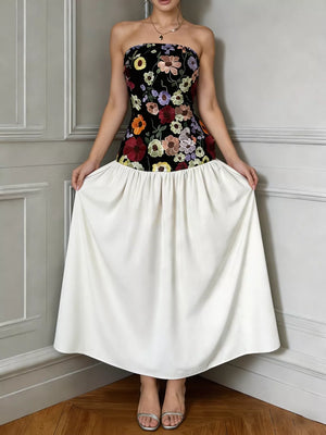 Strapless maxi dress with floral embroidery on black bodice and white skirt.
