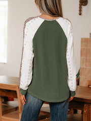 Dark green waffle knit henley top with white lace sleeves and leopard print detail.