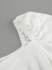 White off-shoulder midi dress with ruched neckline detail and textured fabric.