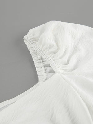 White off-shoulder midi dress with ruched neckline detail and textured fabric.