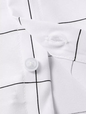 White cotton overshirt with black plaid print, showing button detail.