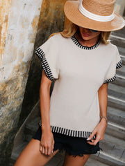 Beige knit t-shirt with black and white striped trim on sleeves and neckline.