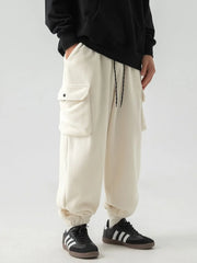 Ivory fleece cargo jogger trousers with drawstring waist and button flap pockets.