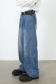 Medium wash denim trousers with prominent vertical seams and a wide leg