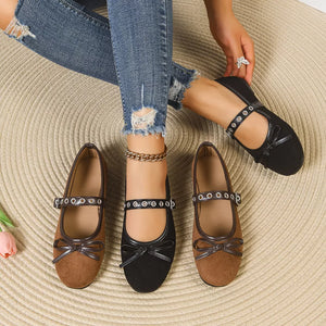 Black and brown Mary Jane flats with bow detail and eyelet strap.