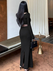 Black long-sleeve maxi dress with sheer mesh waist detail and side slits.