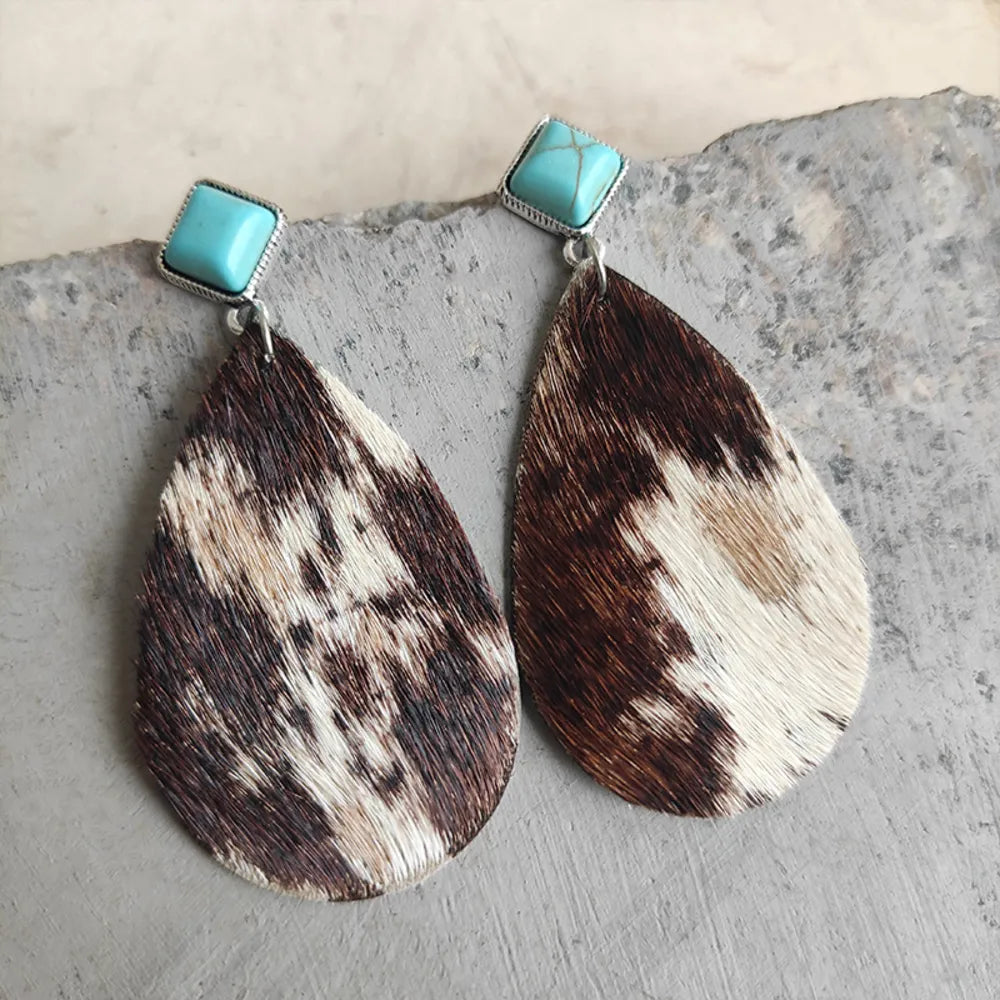 Textured cow print teardrop earrings with turquoise square tops