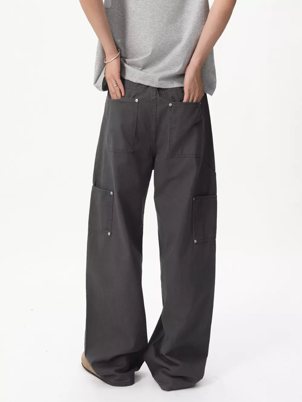 Relaxed wide-leg cargo pants in gray cotton with multiple buttoned pockets.