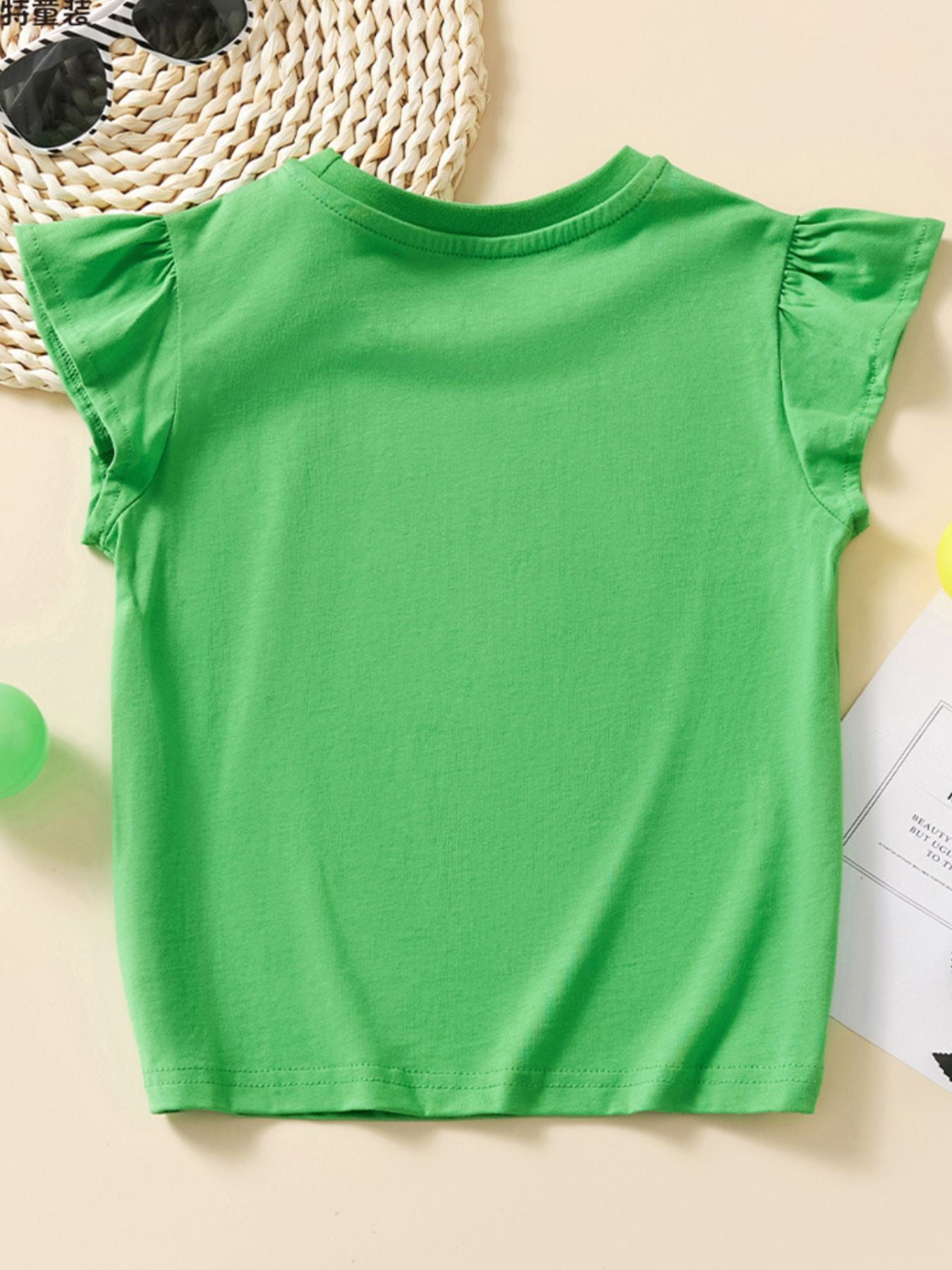 Green cotton cap sleeve t-shirt with ruffled sleeves and a round neckline.
