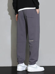 Men's grey cuffed jogger pants with a back pocket and subtle logo detail.