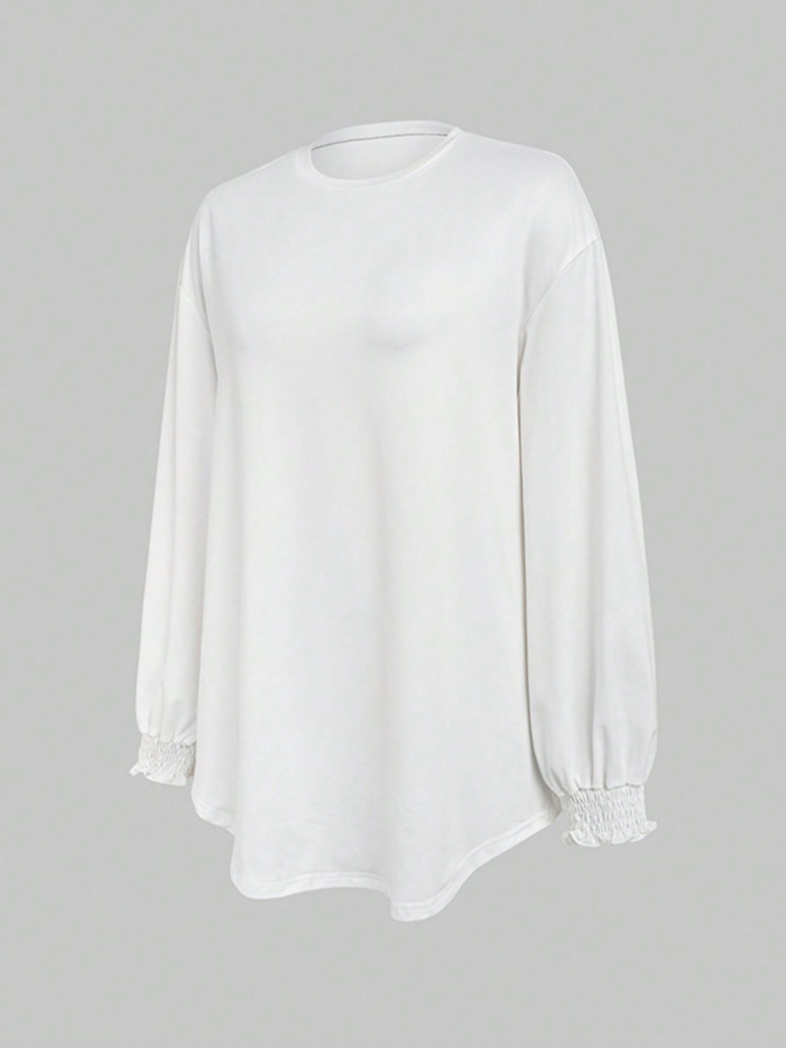 White oversized tunic top with long sleeves and ruffled cuffs.