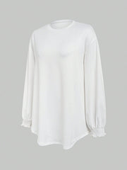 White oversized tunic top with long sleeves and ruffled cuffs.