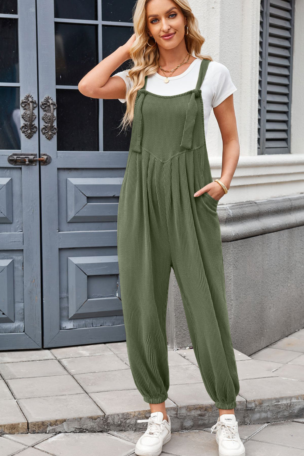 Olive corduroy overalls with barrel leg and pleated detail, worn with a white t-shirt.