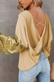 Light yellow waffle knit top with sequin sleeves and crisscross back detail.