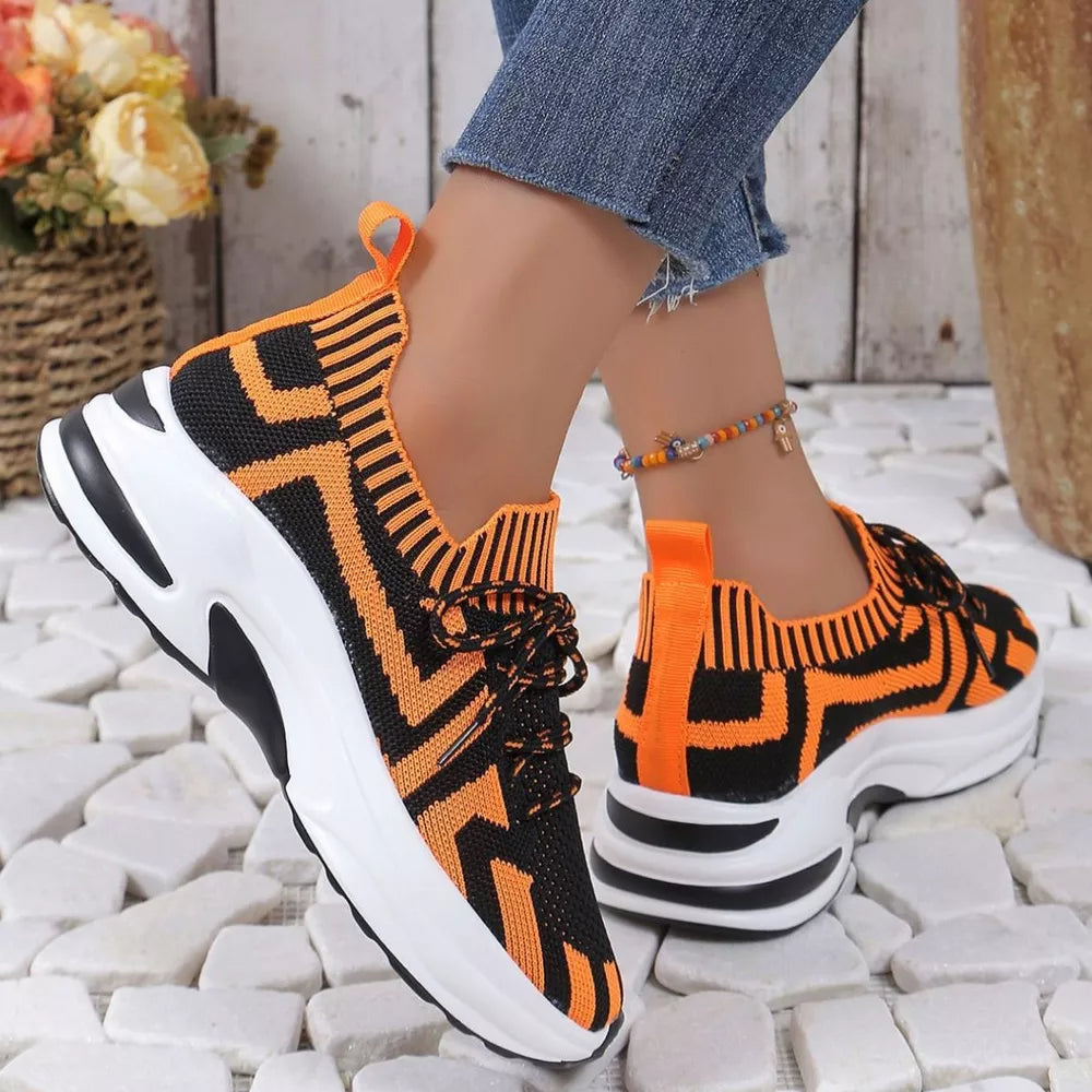 Geometric knit platform sneakers in orange and black with white soles.