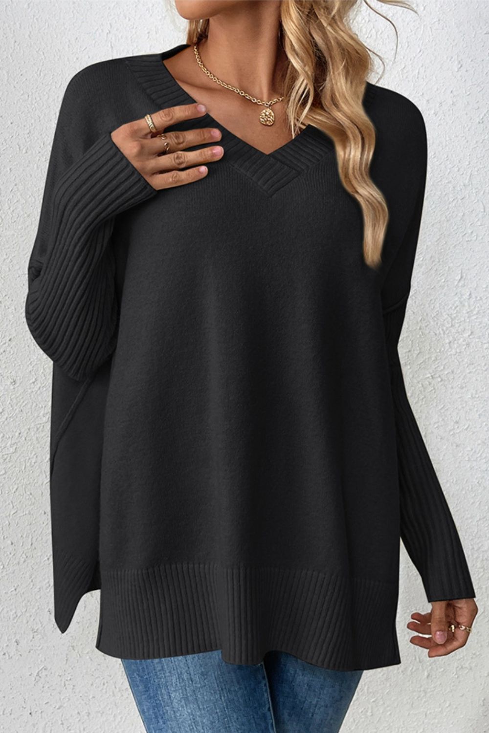 Black V-neck knit sweater with ribbed sleeves and asymmetric hemline