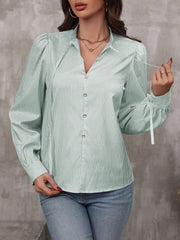 Green striped blouse with puff sleeves, V-neck, and tie cuffs.