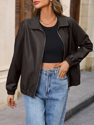 Brown faux leather bomber jacket with zip front and elastic cuffs, styled casually.