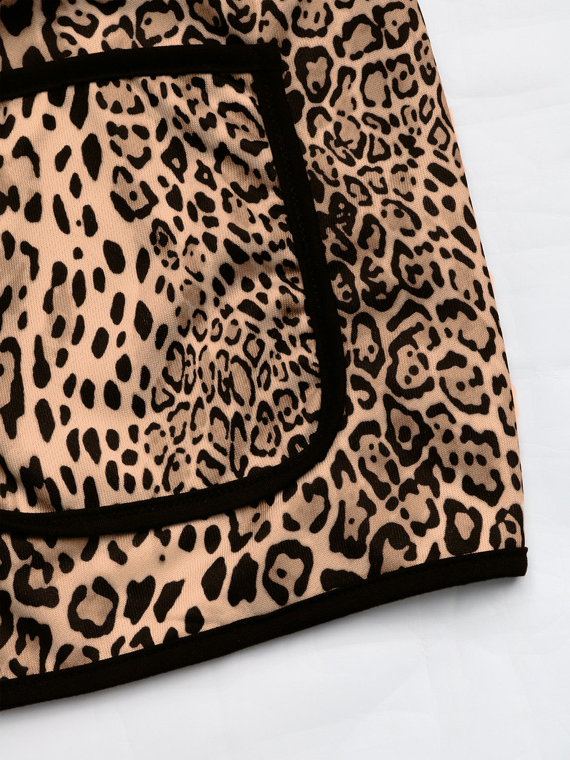 Leopard print boxy jacket with black edge trim and pocket detail.