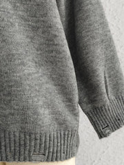 Dark gray relaxed knit sweater with distressed details on the hem and cuffs.