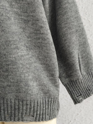 Dark gray relaxed knit sweater with distressed details on the hem and cuffs.