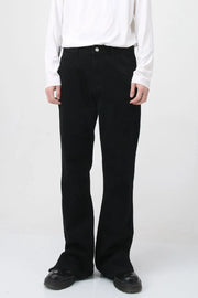 Flared hem denim trousers in dark cotton, styled casually.