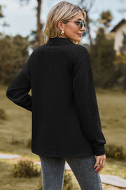 Black textured polo-neck sweater with button detail, long sleeves.