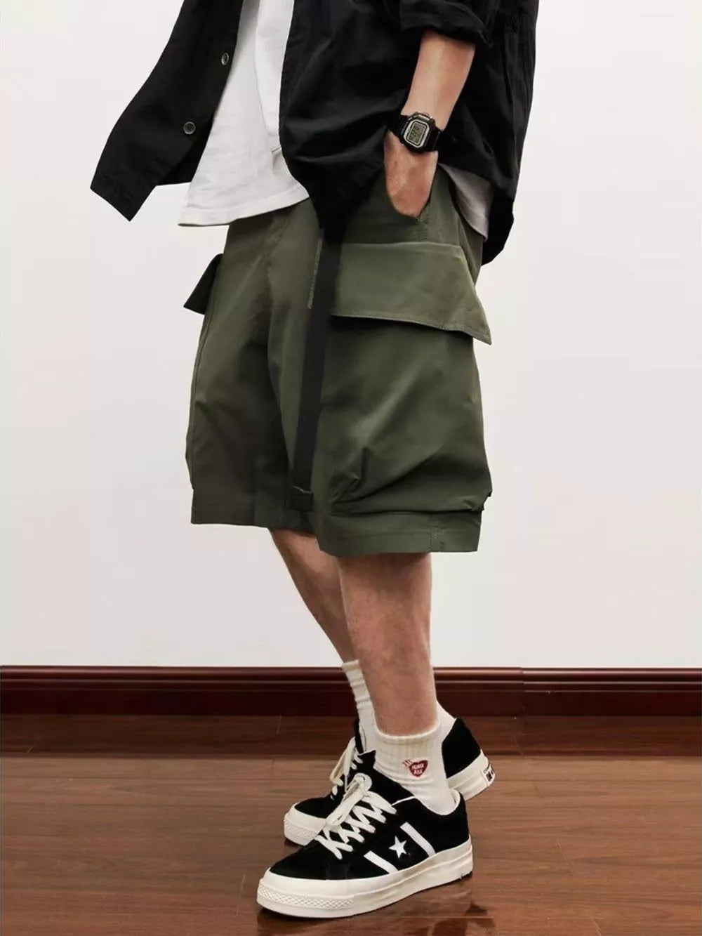Men's relaxed fit olive green cargo shorts with large flap pockets and a black belt detail.