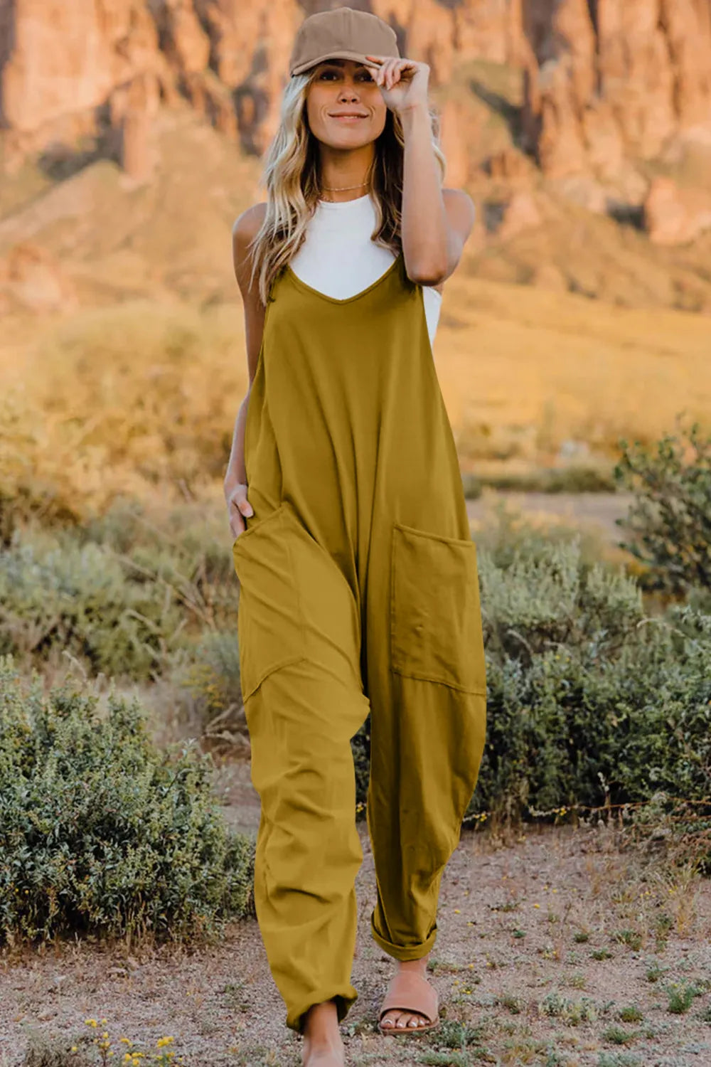 Mustard V-neck wide-leg jumpsuit with pockets and cuffed ankles.