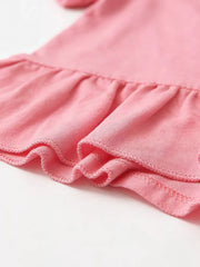 Pink baby ruffle top detail with textured fabric and stitched hem.